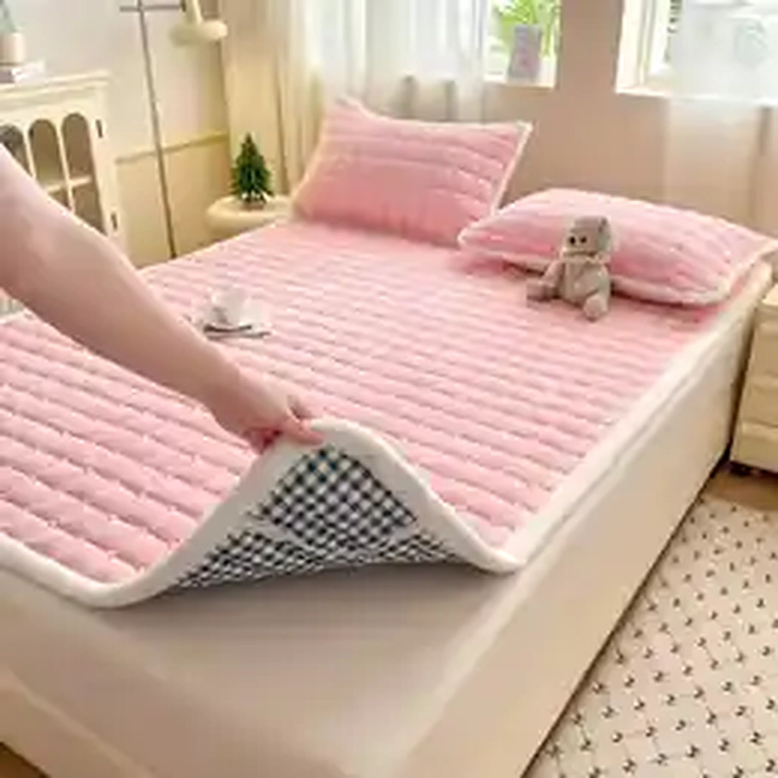 Pink quilted fleece mattress pad on bed